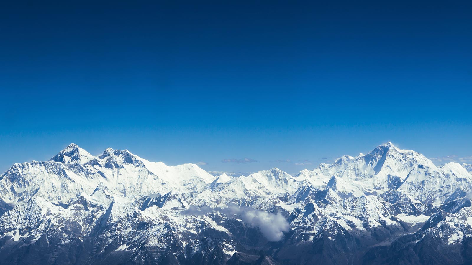 Image of mountains covered with snow with a clear blue sky